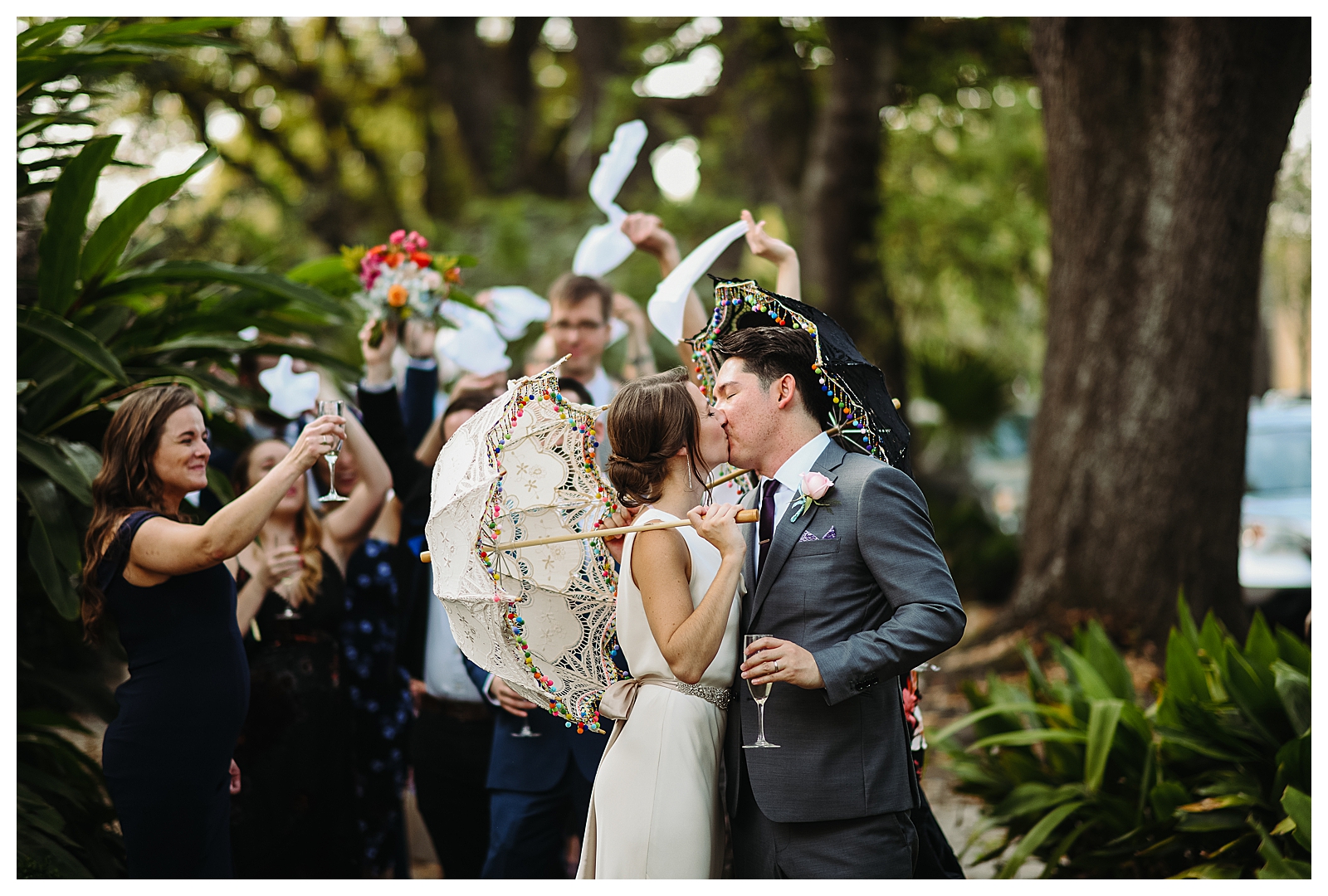 A couple holds decorated wedding umbrellas for a wedding parade in New Orleans.