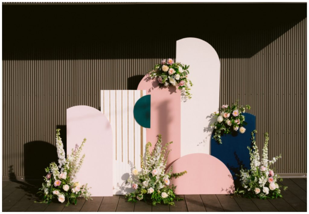 Custom pink, white, and blue backdrop for the rooftop ceremony with flowers