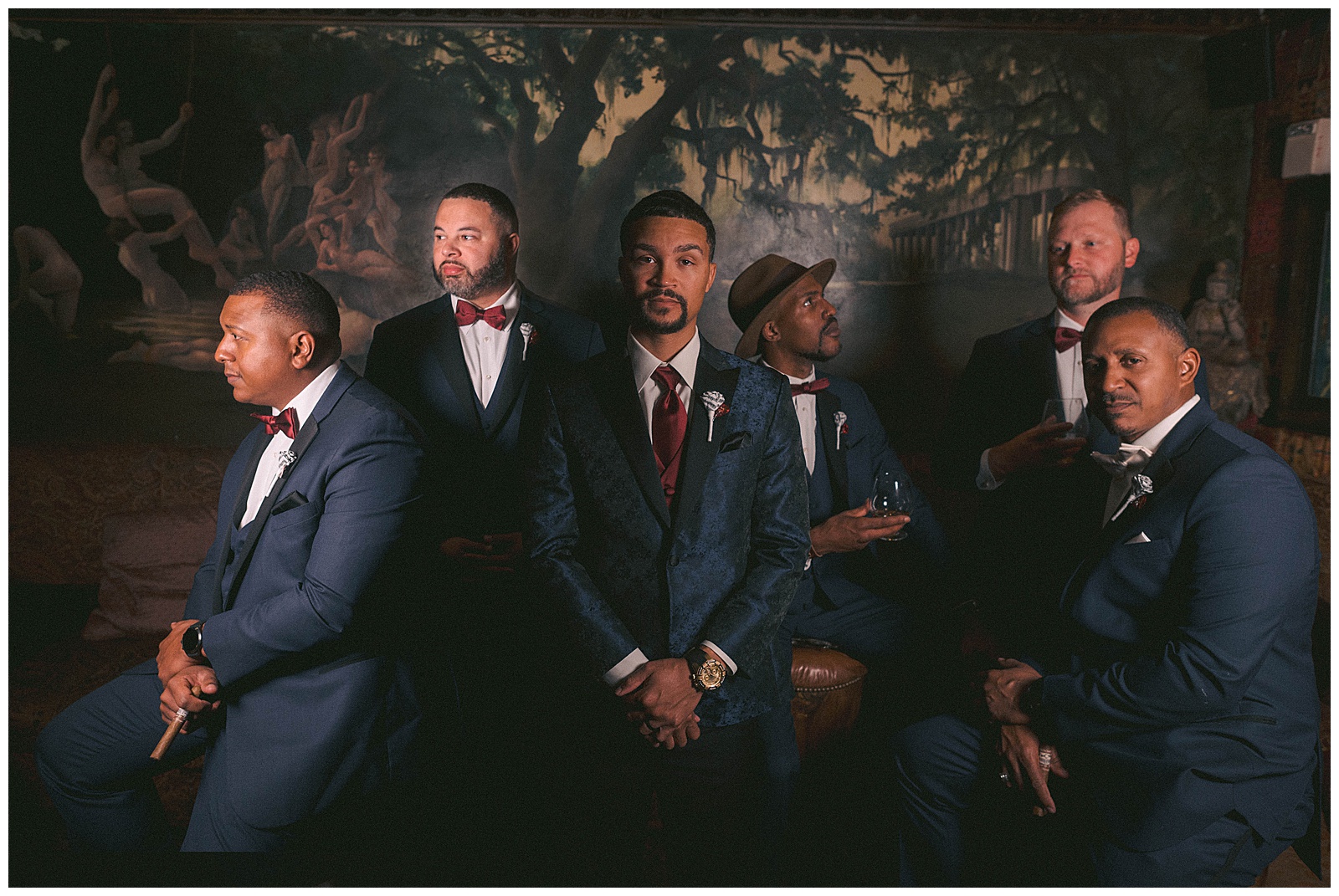 A groom and groomsmen sit in their wedding outfits at the House of Blues