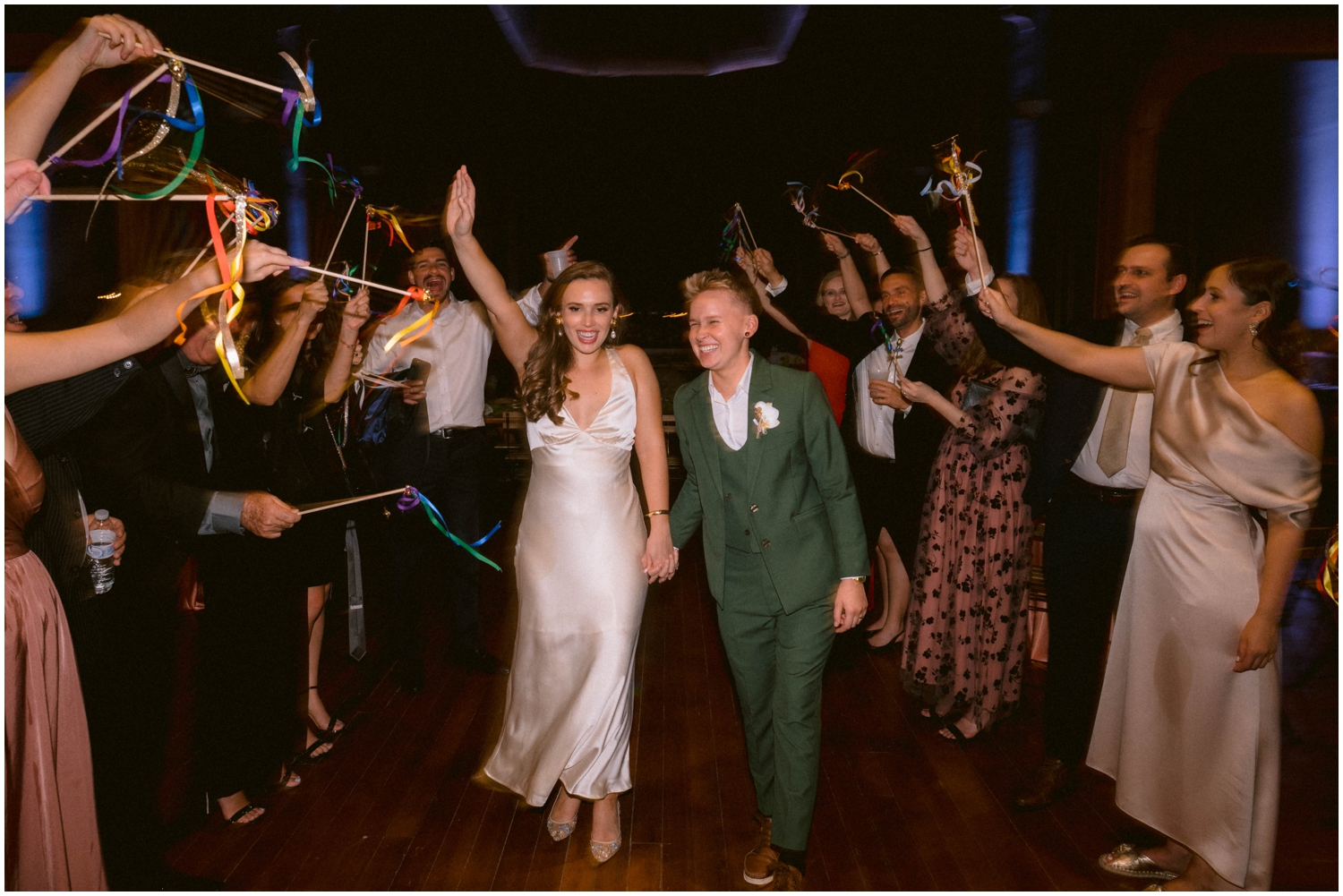 Han and Alyssa walk between lines of guests waving streamers for their wedding exit.