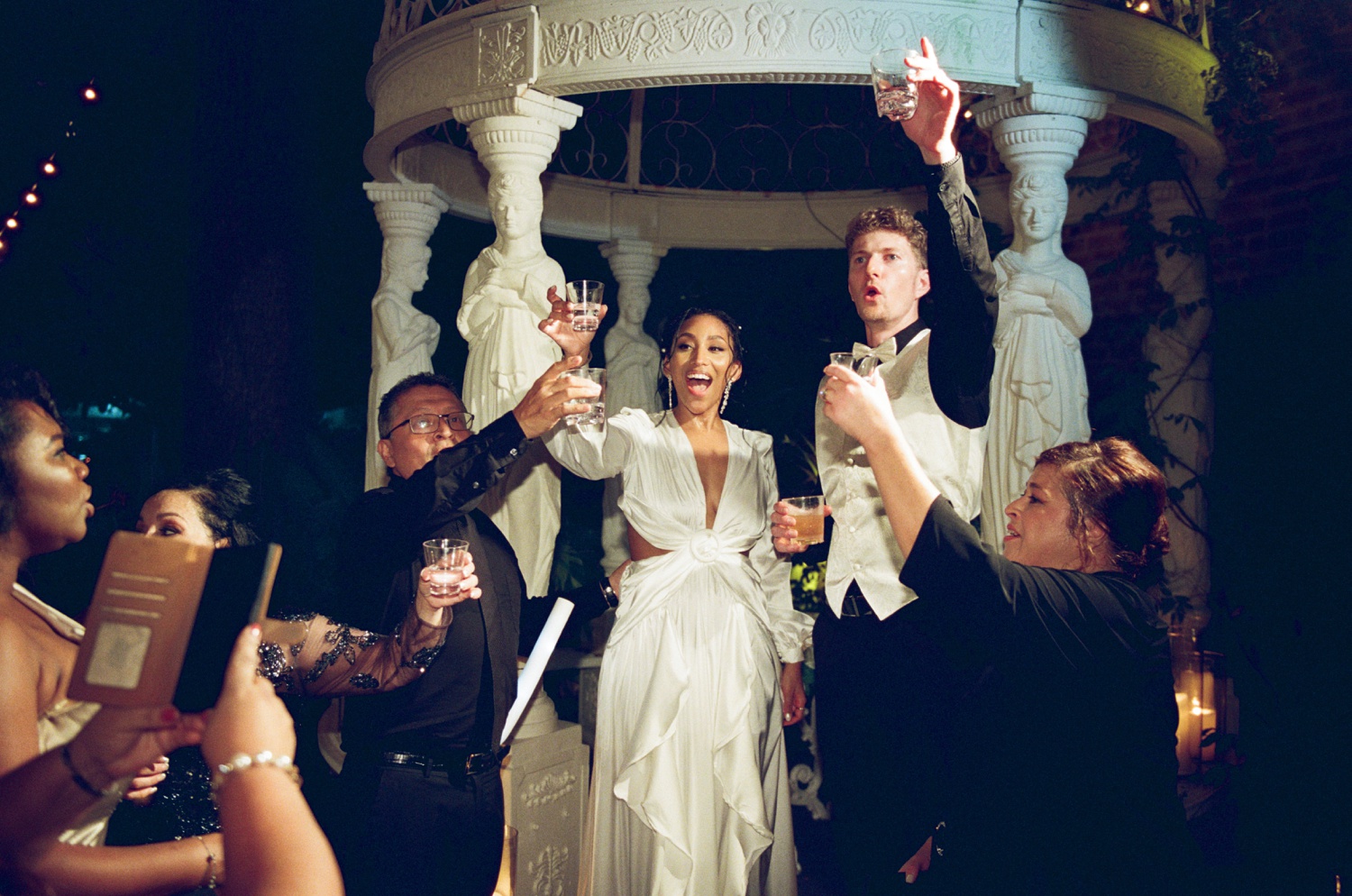 A bride and groom raise glasses for a wedding toast in film wedding photography at a Philadelphia wedding venue.
