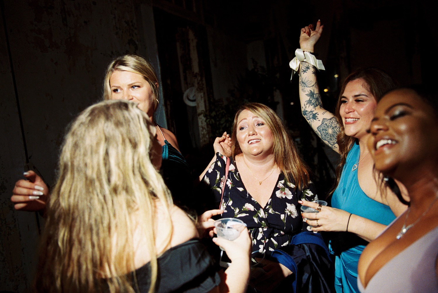 Wedding guests dance with their hands in the air.