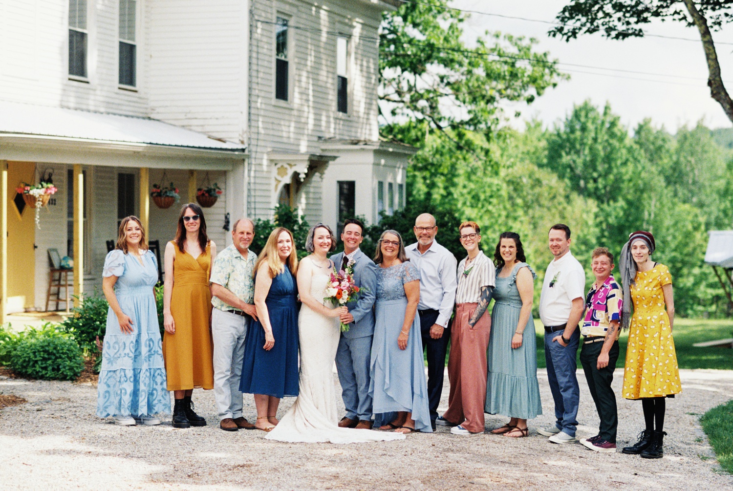 A couple poses with family members for a formal wedding portrait outside a Maine wedding venue.