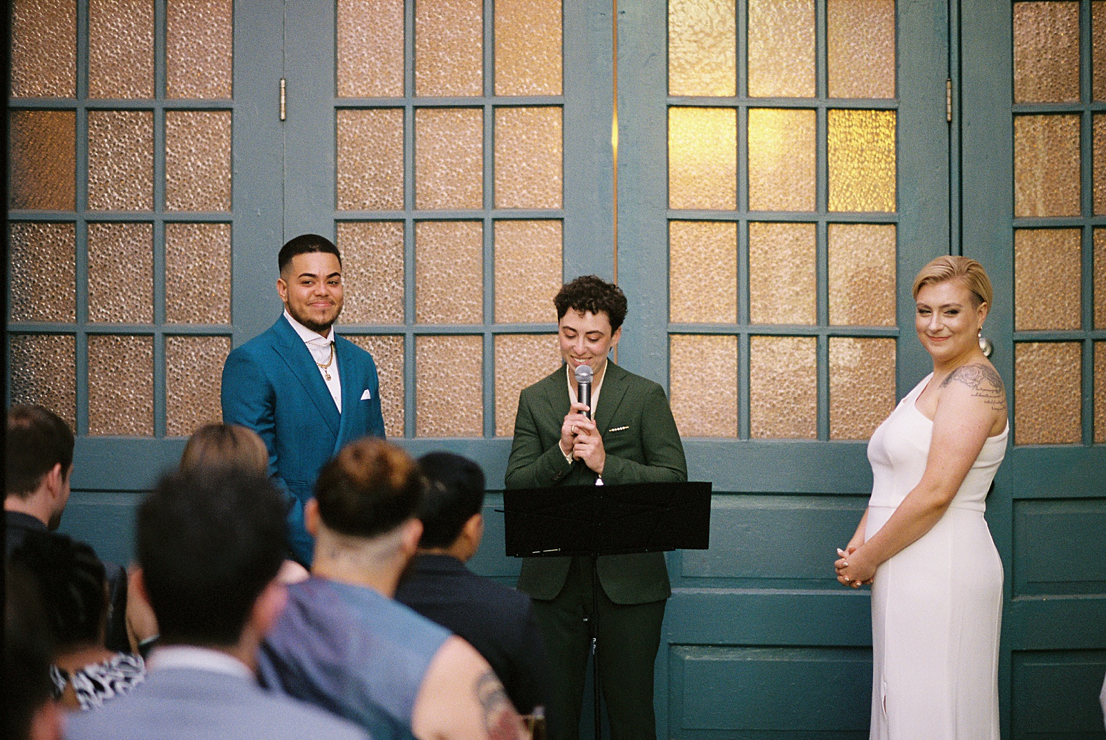A wedding officiant speaks into a microphone at a Maas Building wedding.