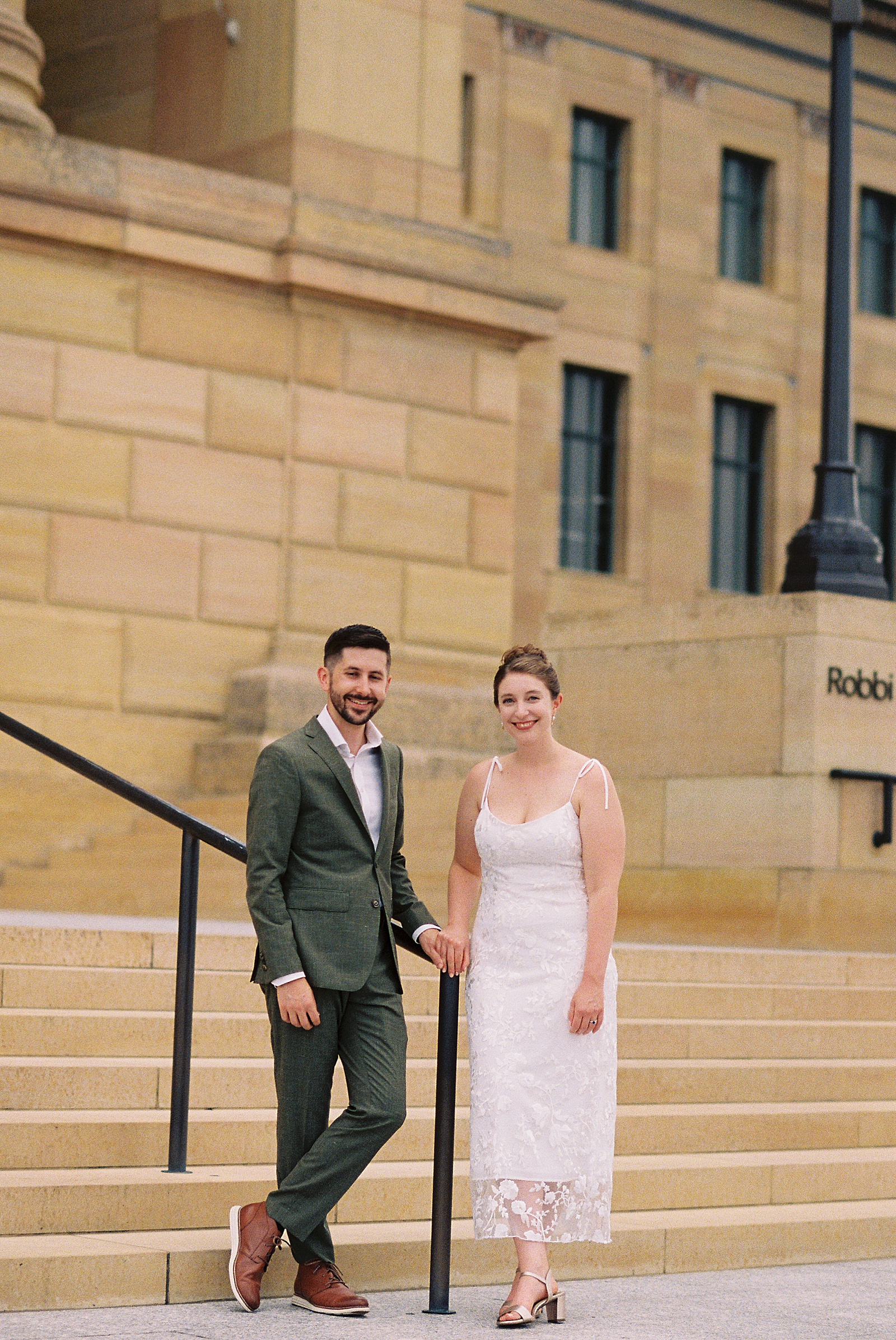 A bride and groom pose on the steps of the Philadelphia Museum of Art.
