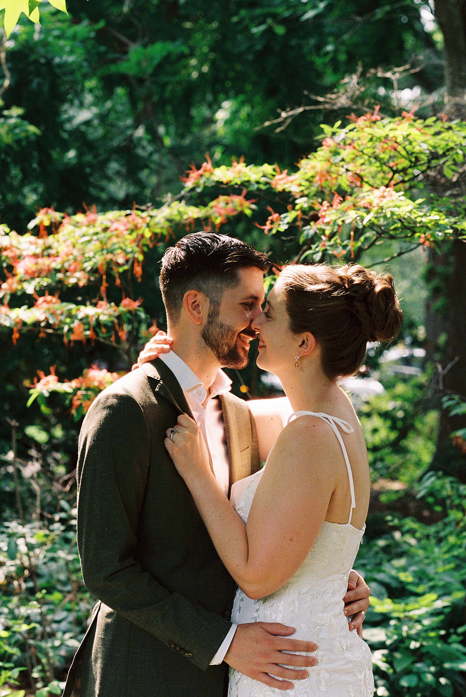 A bride and groom kiss in a Philadelphia garden on film photography.