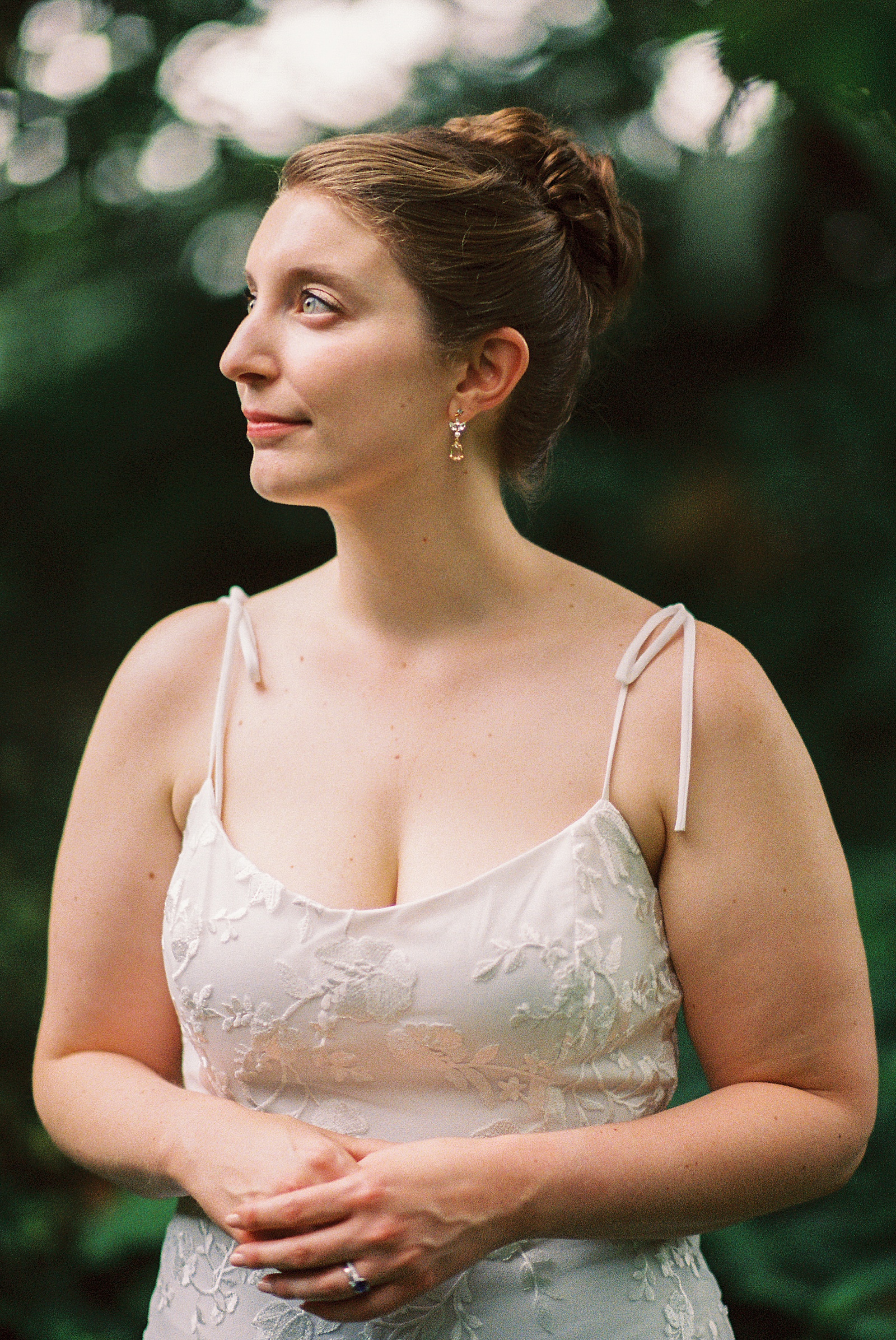 A bride smiles at something out of frame in a film wedding portrait.