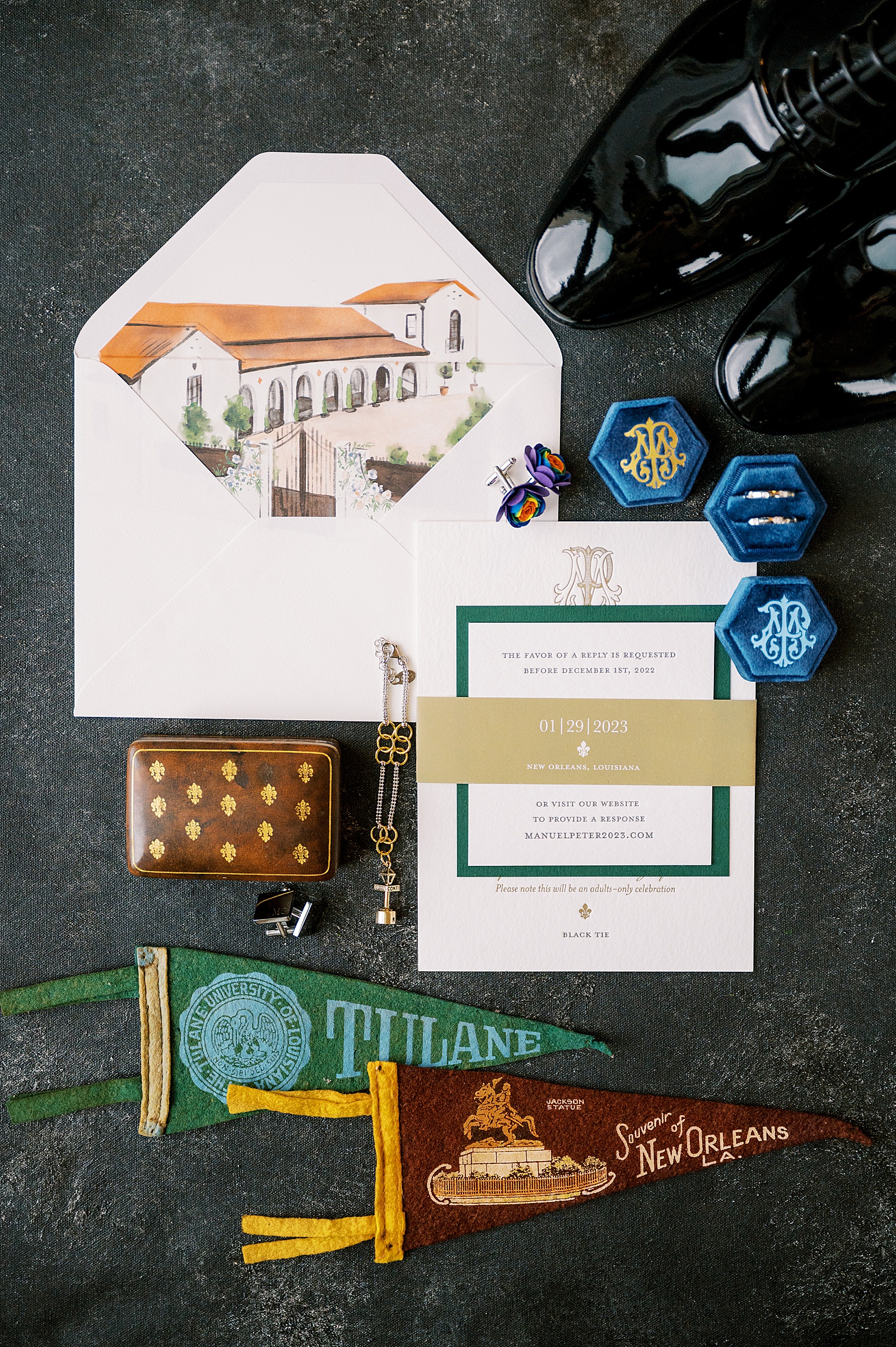 A wedding invitation suite sits on a green backdrop.