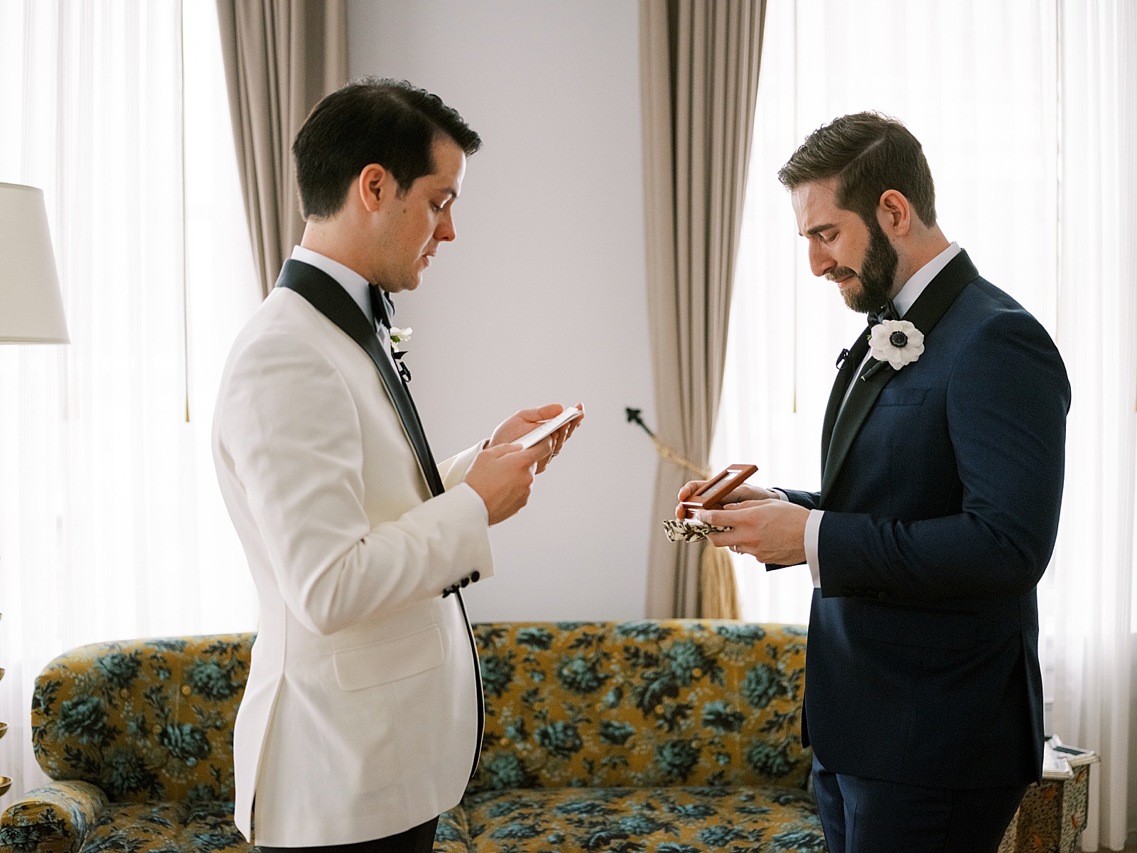 Two grooms exchange wedding day gifts in a hotel suite.