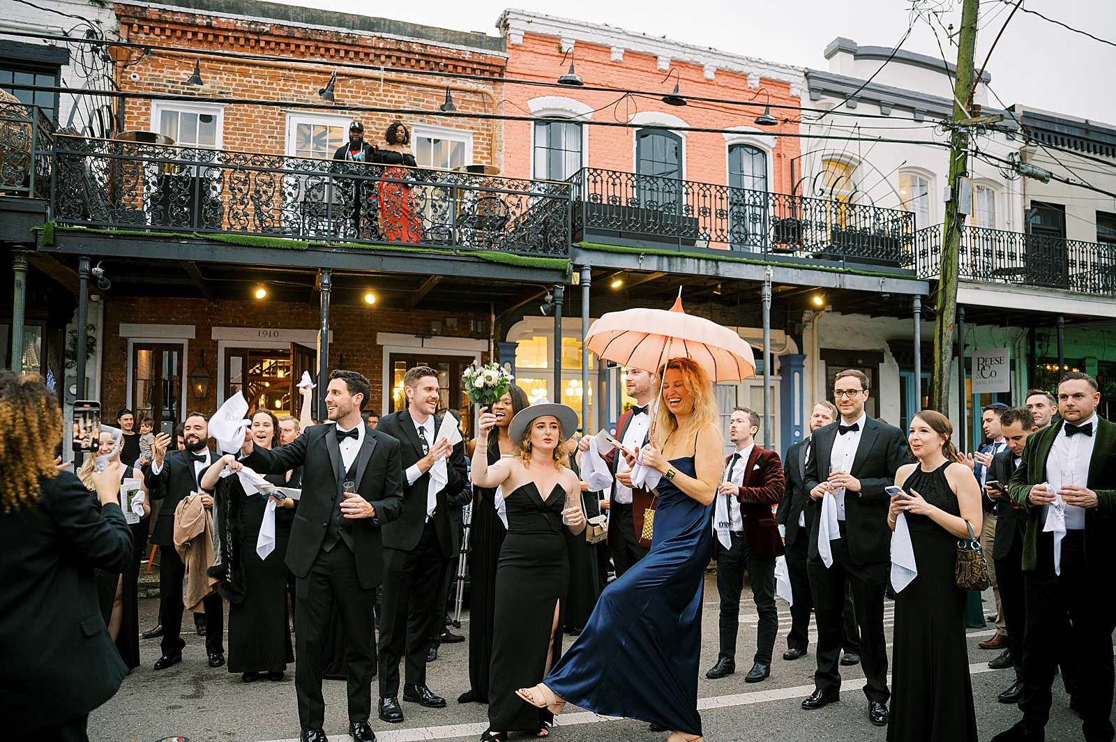 Wedding guests dance down a New Orleans street during a wedding second line.