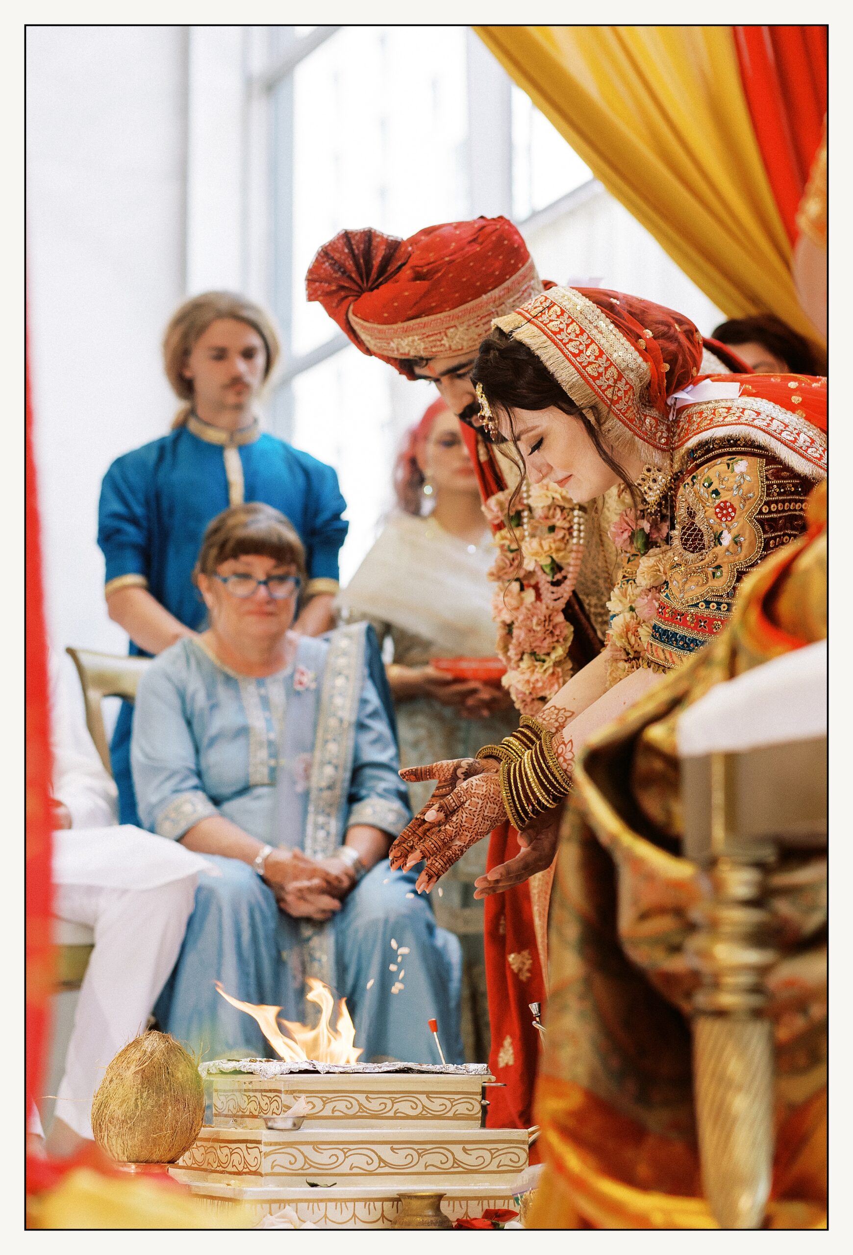 A bride and groom throw an offering on a fire during an Indian wedding ceremony in the Loews Philadelphia ballroom.