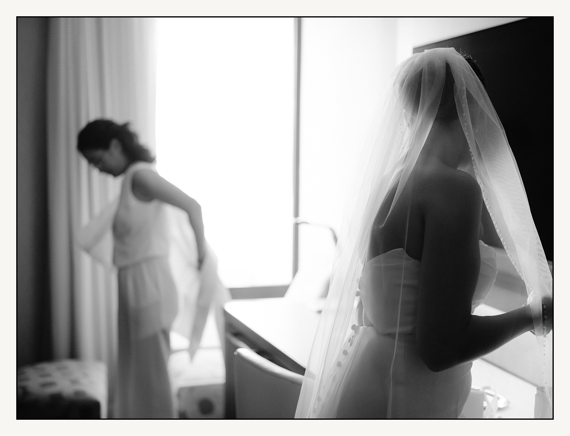 Two brides put on wedding attire in a Philadelphia hotel.