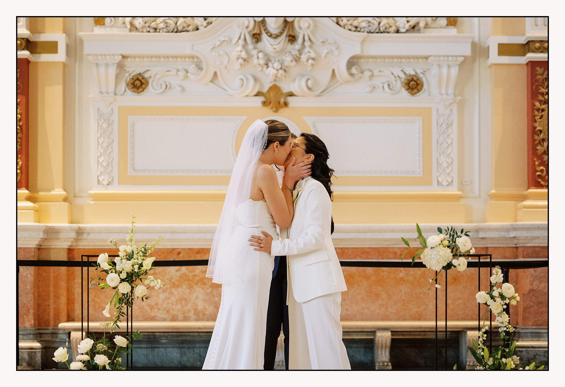 Two brides share their first kiss at their Please Touch Museum wedding in a film photo.